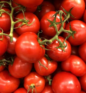 Vibrant close-up of fresh cherry tomatoes, showcasing their juiciness and bright red color.