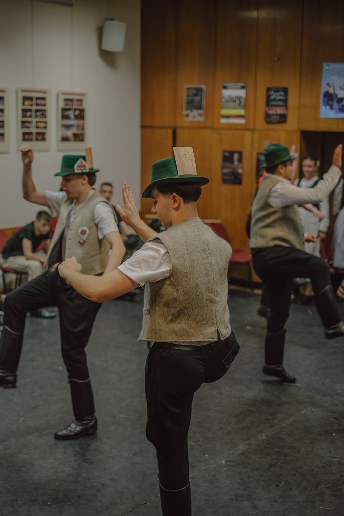 A group of men in traditional Bavarian attire perform a lively dance indoors.
