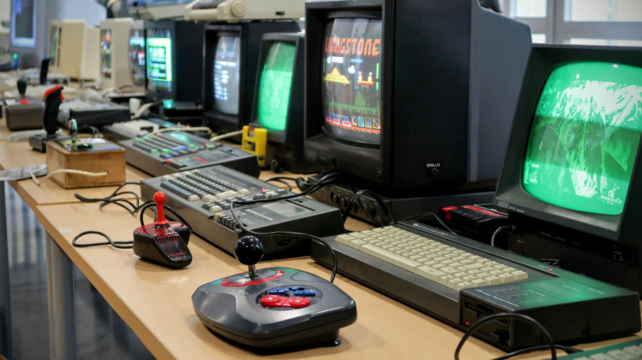 A row of computer monitors sitting on top of a desk