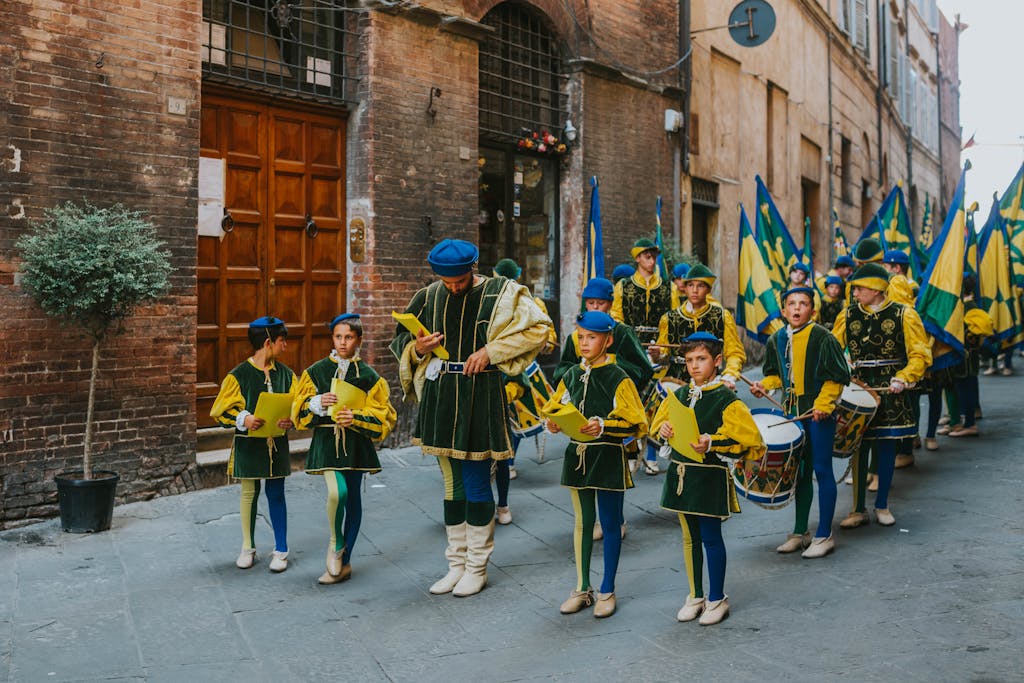Children in colorful medieval costumes during a historic parade on a city street.