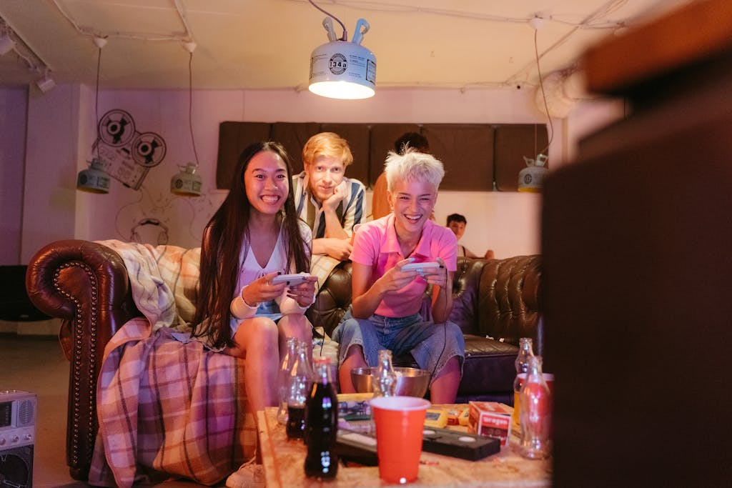 Group of friends playing video games and having fun indoors with snacks and cozy vibes.