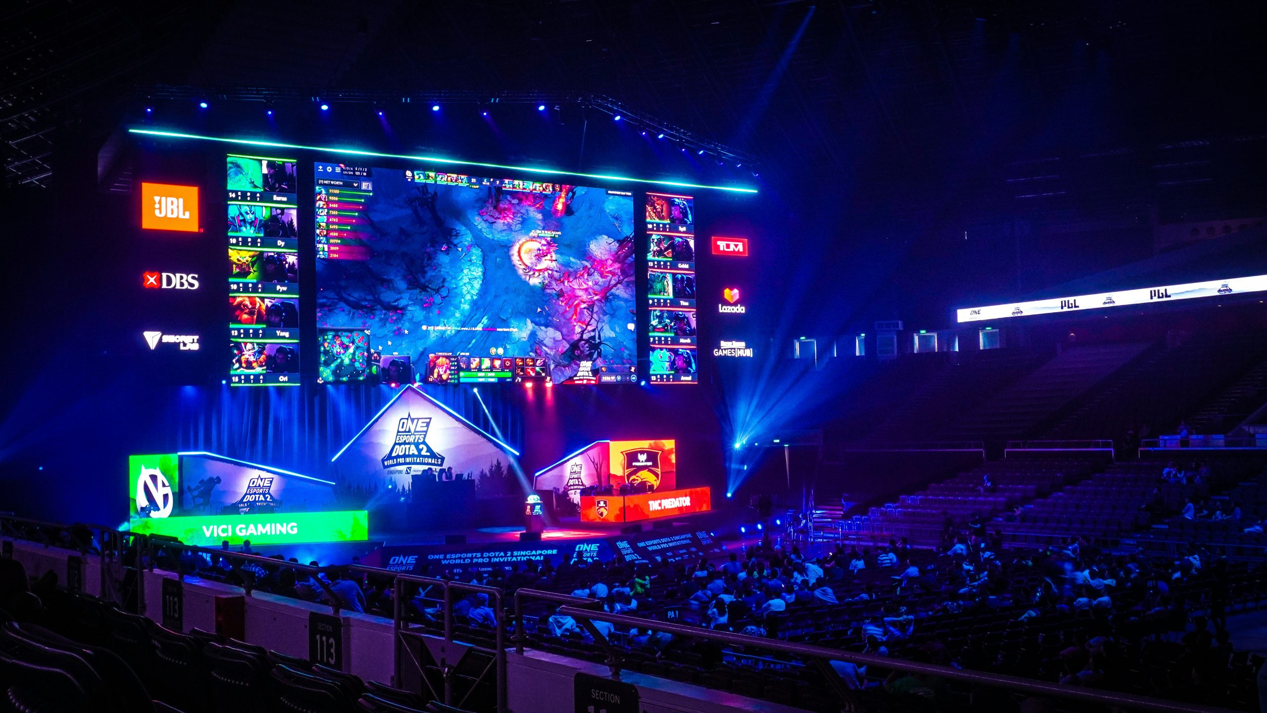 Crowd of people watching a game tournament on a big screen in a stadium