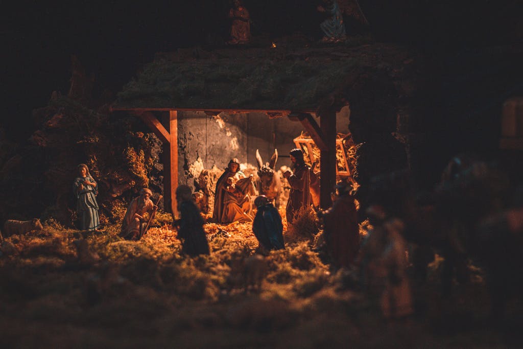 A detailed and festive nativity scene showcasing handcrafted figurines illuminated softly at night.