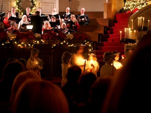 A festive candlelight ceremony with a choir performing at a Seattle church with holiday decorations.