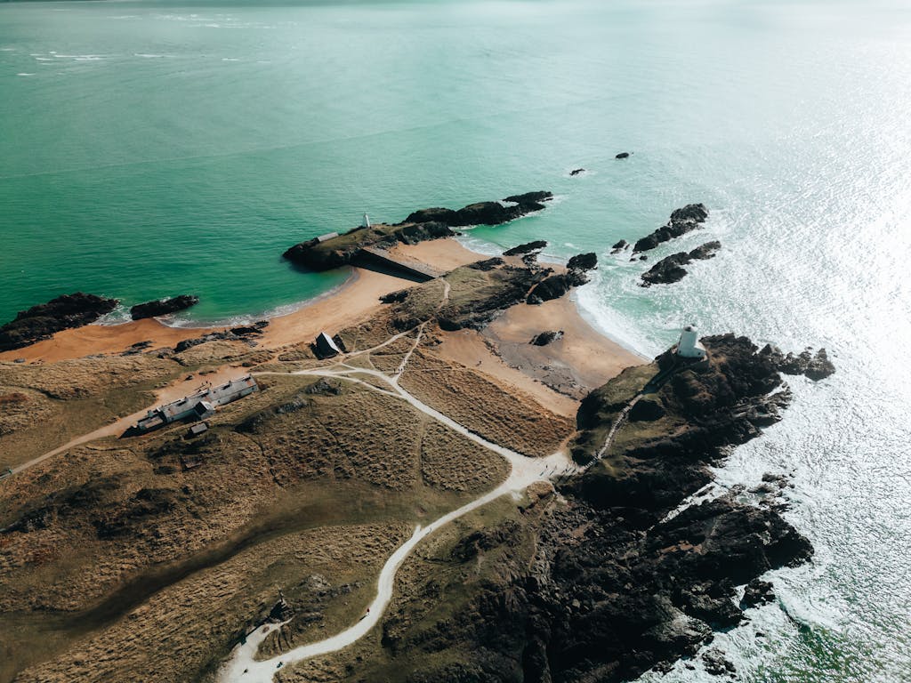 Scenic aerial view of Llanddwyn Island with its lighthouse and rugged coastline in Wales.