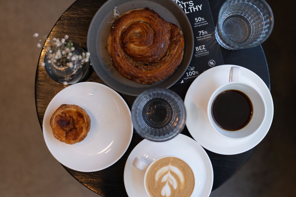 Flat lay of delicious coffee and pastries on a table, creating a sophisticated breakfast scene.